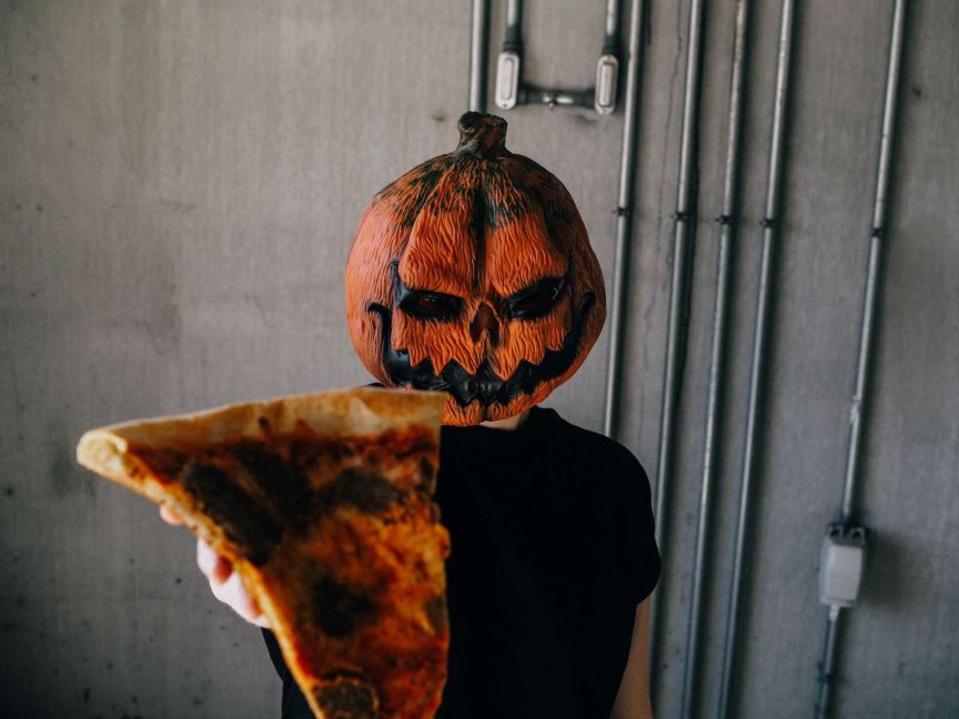 pumpkin head holding pizza