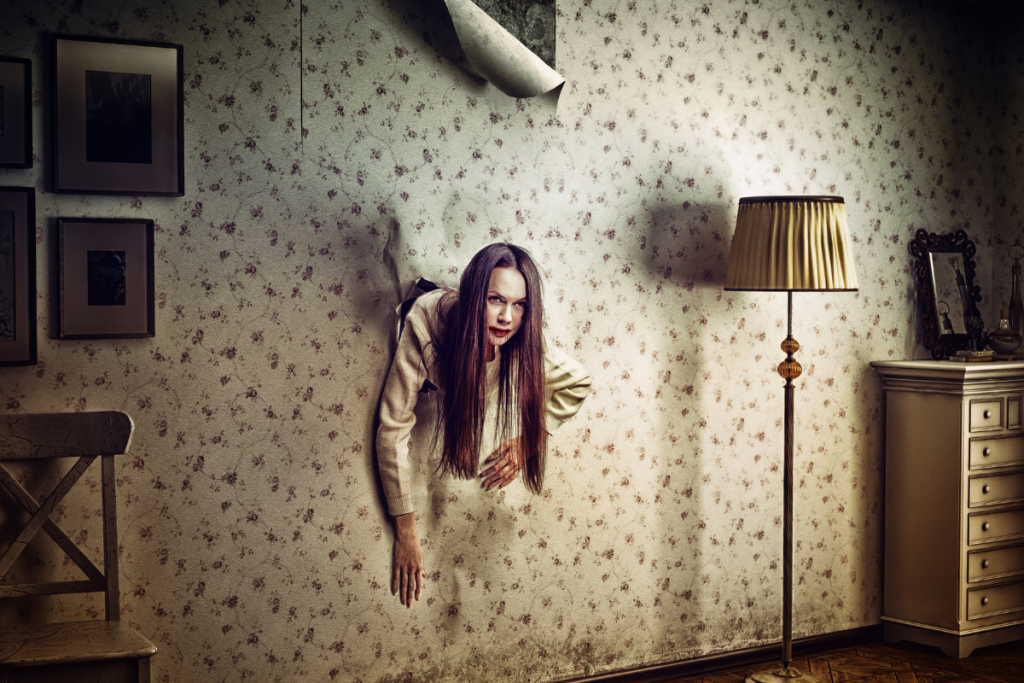 scare-actor coming out of the wall in hunted house living room