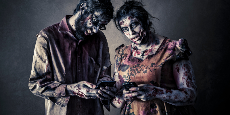 two zombies using cell phones texting