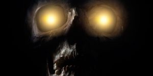 skull with yellow lights shining through eye sockets