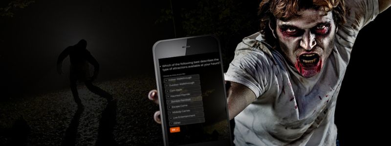 zombie guy holding a mockup of the 2022 haunt industry survey on a mobile phone