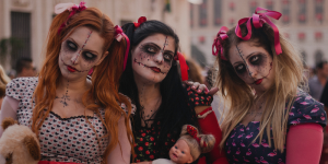Three women dressed as scary dolls standing next to each other.