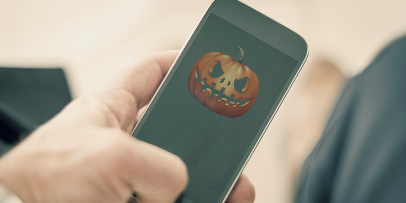 Image of a person holding a phone with a pumpkin on the screen.