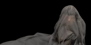 Long black hair doll covered with white sheet on dark background