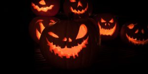 Group of Halloween jack-o-lantern pumpkins glowing in the darkness
