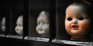 creepy collection of severed, dirty baby doll heads on a shelf
