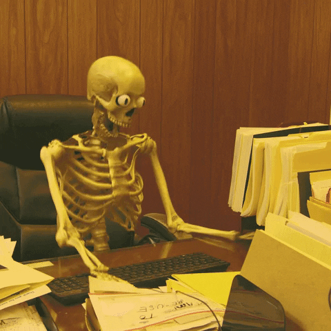 Skeleton jumping up and down with excitement at their desk