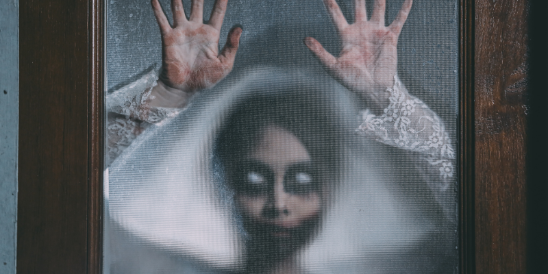 creepy woman pressing against a glass door
