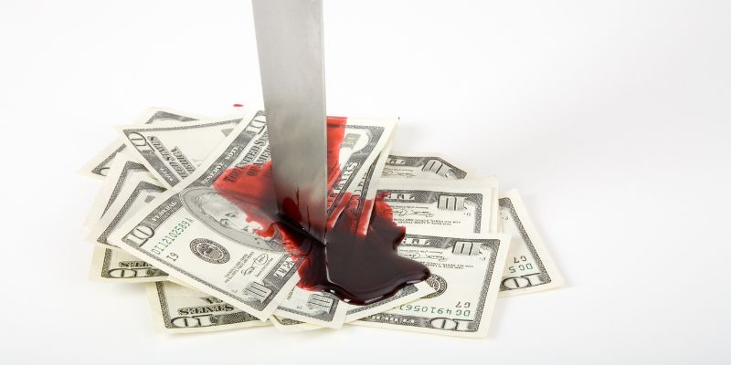 Knife stabbed in money and blood spilling from it