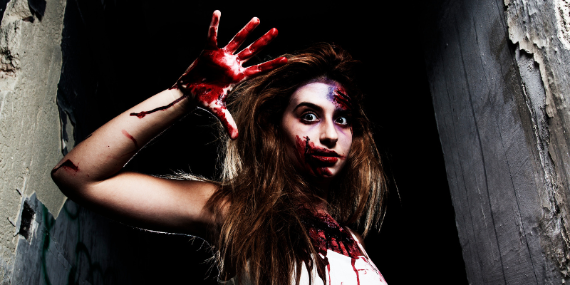 Woman covered in fake blood and bruises.