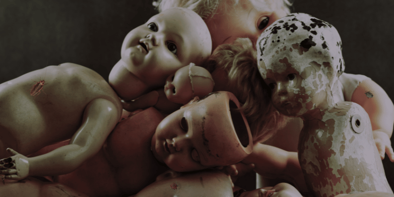 Cursed creepy dolls laid on top of each other